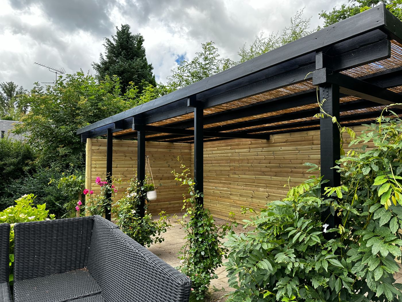 Sortmalet pergola i træ over terrasse